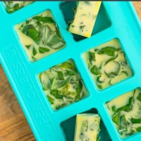 a teal Souper Cube with cubes of chopped basil frozen with olive oil.