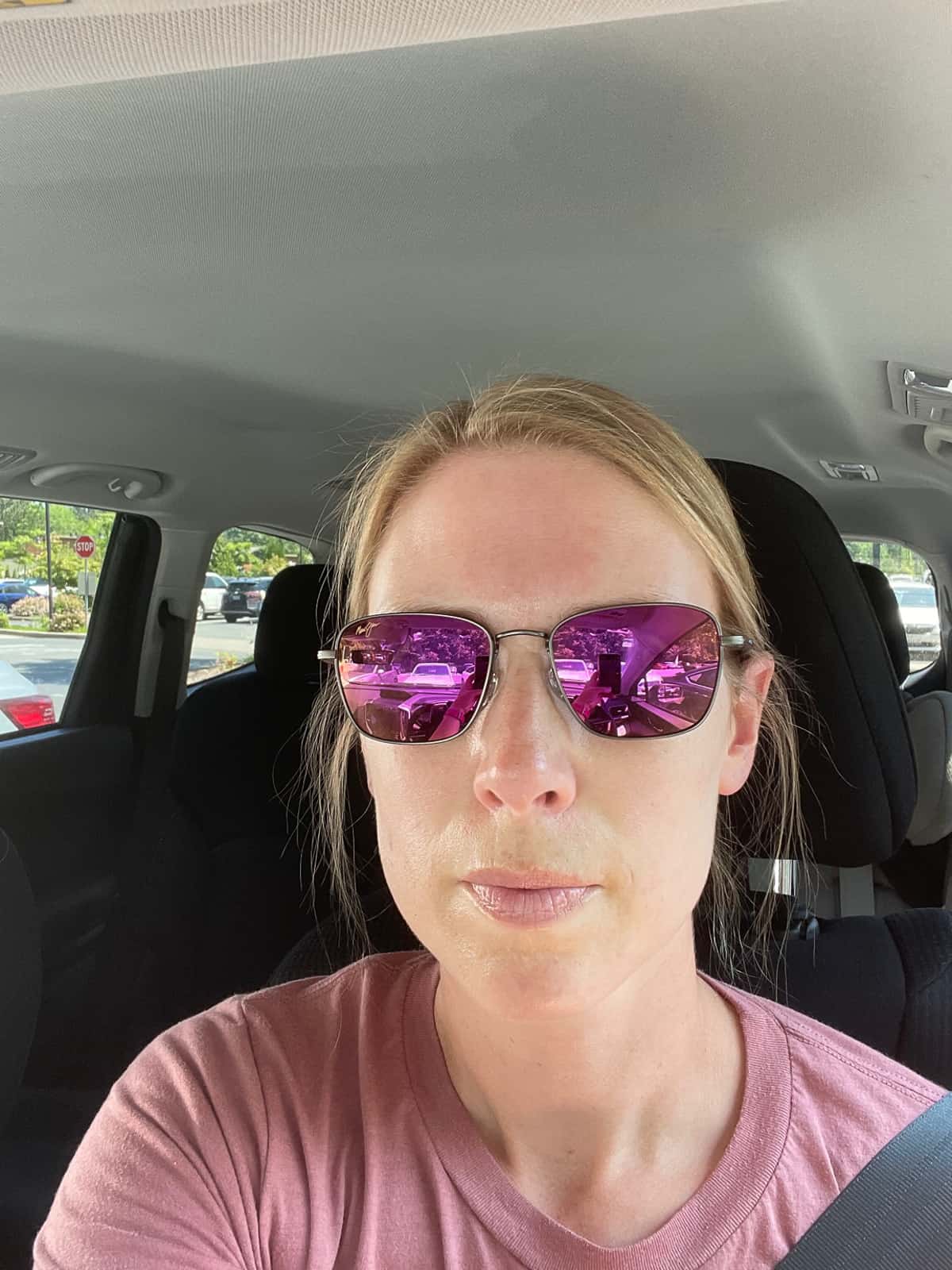 a woman in a car wear sunglasses