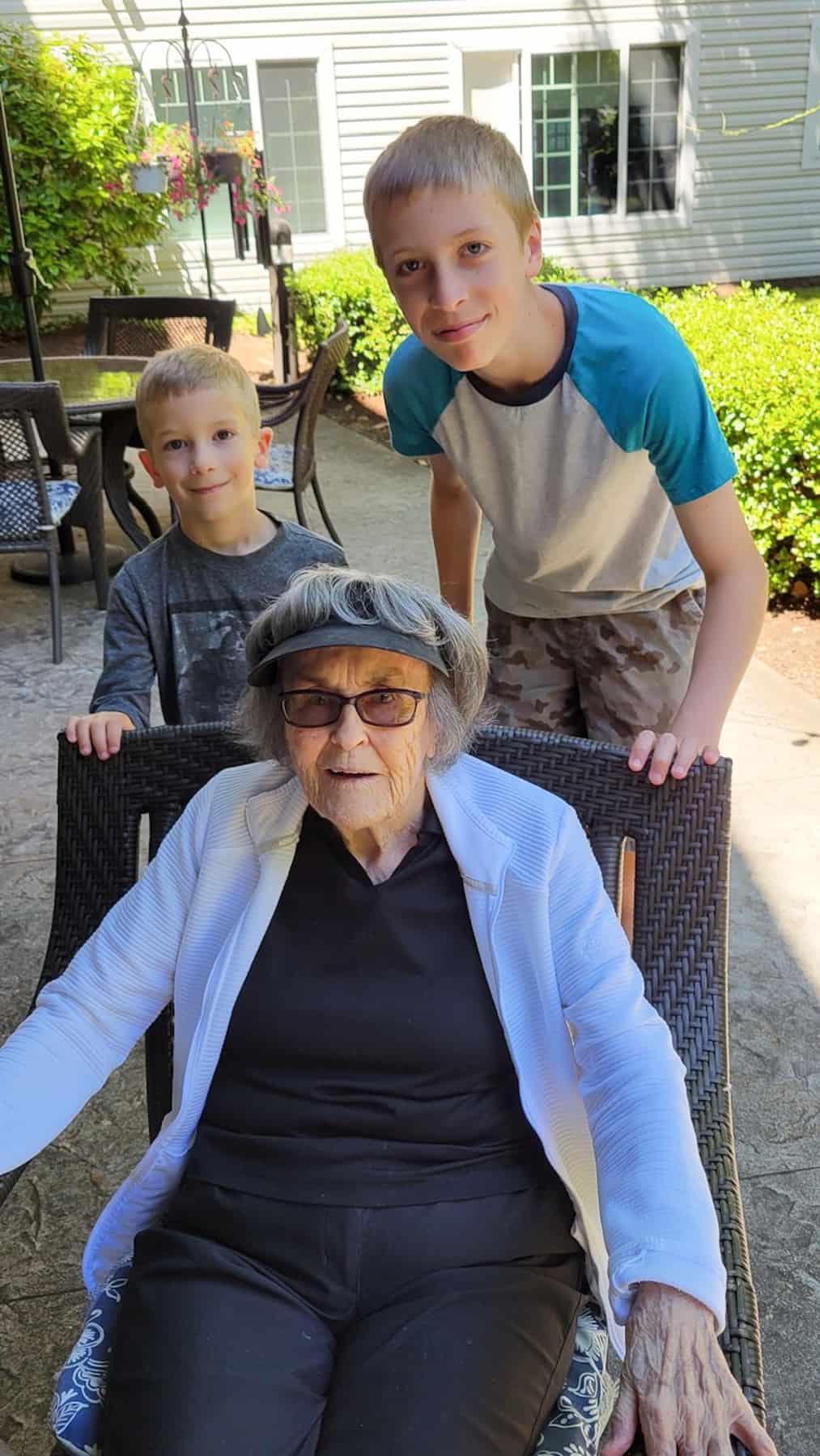 2 boys standing with their great grandma