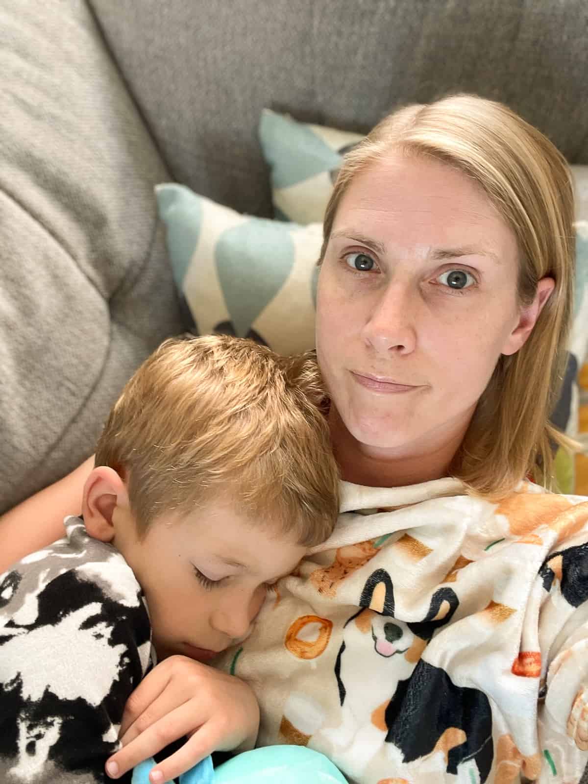 a mom and son snuggling on the couch.