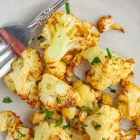 roasted cauliflower on a grey plate with fork.