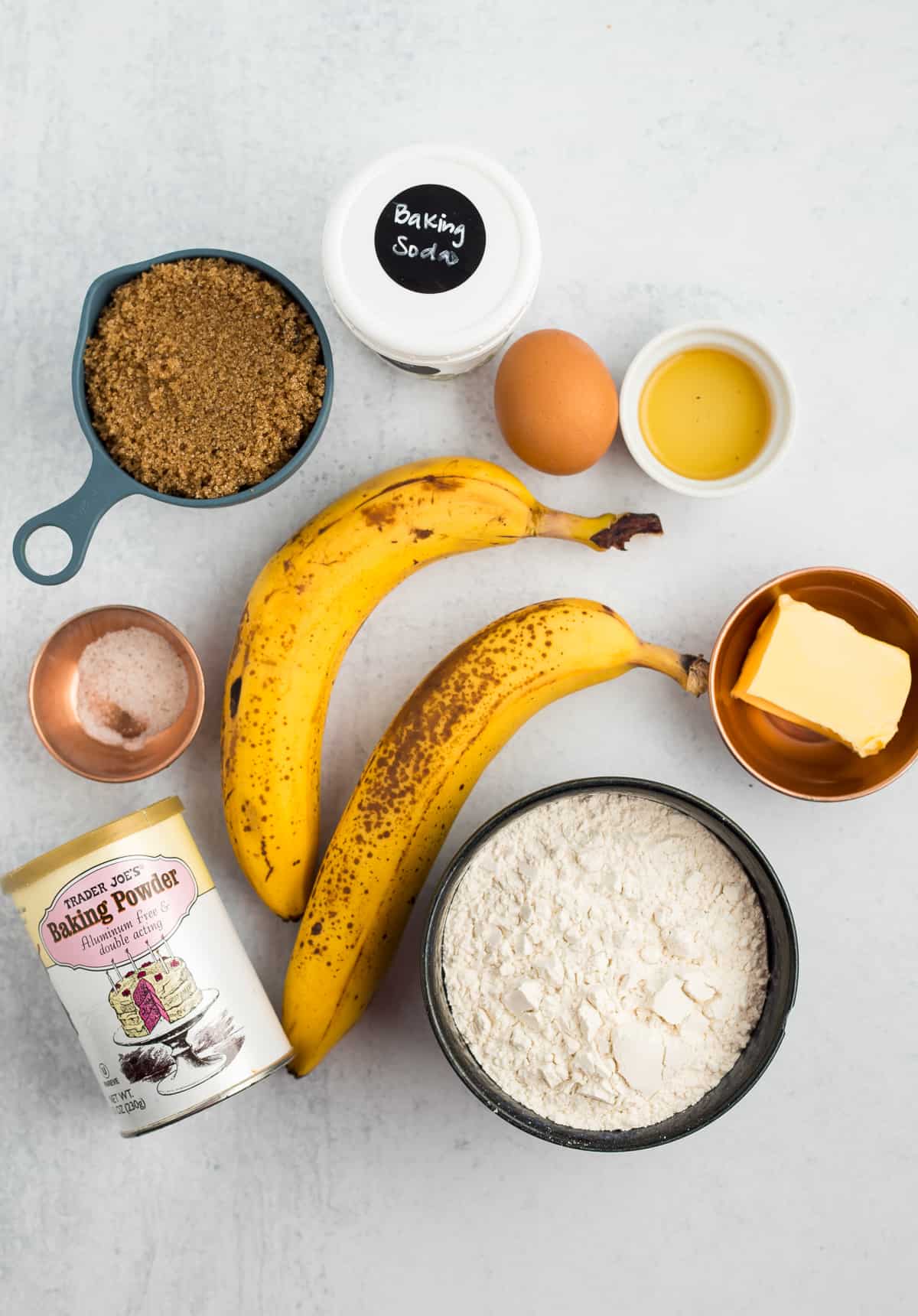 bananas, butter, an egg, brown sugar, and other ingredients for making quick bread.