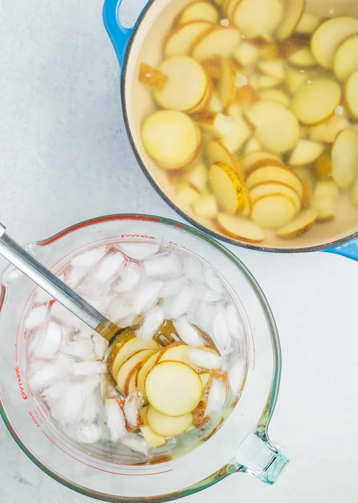 sliced potatoes in a bowl of ice water.