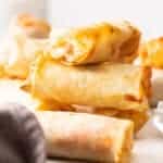 a stack of pizza egg rolls on a white board.