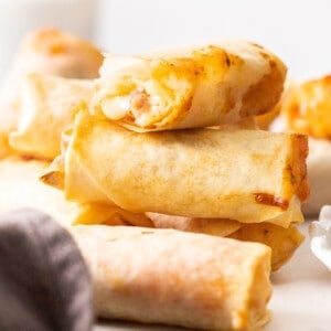 a stack of pizza egg rolls on a white board.