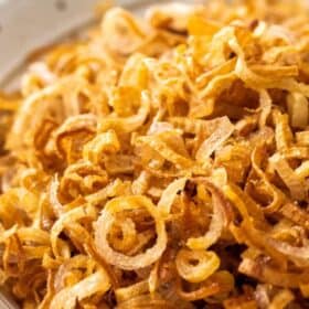 a beige bowl of fried shallots.