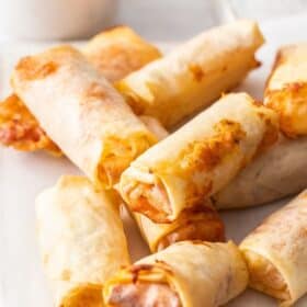 a stack of pizza egg rolls on a white board.