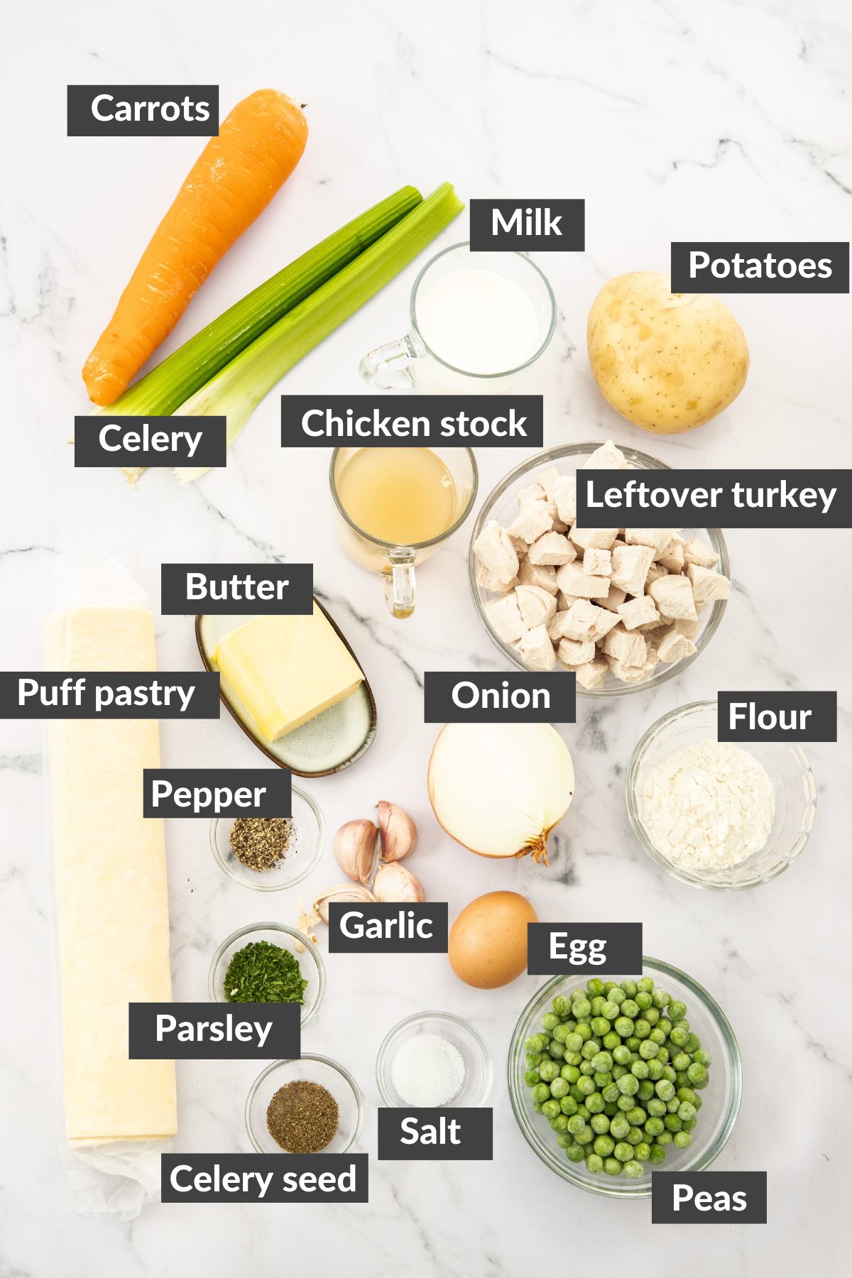vegetables, puff pastry, potatoes, chicken stock, diced turkey, and other ingredients on a marbled board.