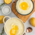 two bowls of fluffy mashed potatoes with melting butter.