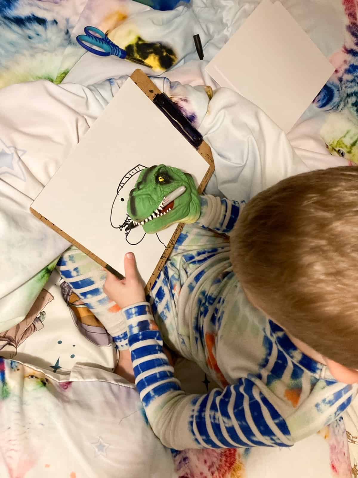 a kid with a dino hand coloring a dino.