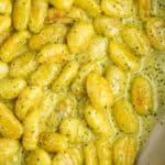 a dish of toasted gnocchi in a pesto cream sauce.