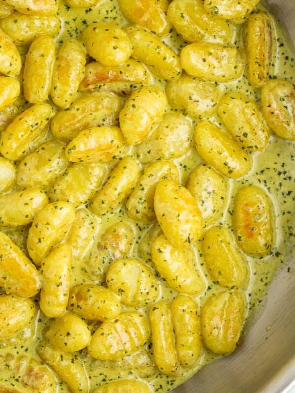 a dish of toasted gnocchi in a pesto cream sauce.