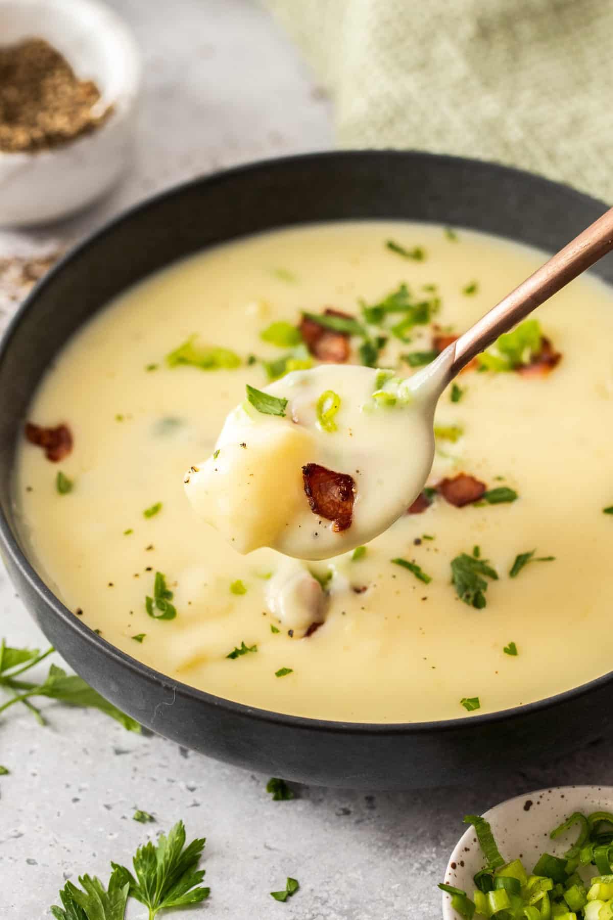 a spoonful of potato soup over a bowl.