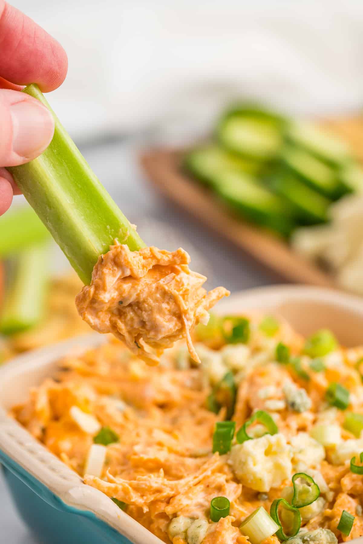 a piece of celery scooping a portion of buffalo chicken dip.