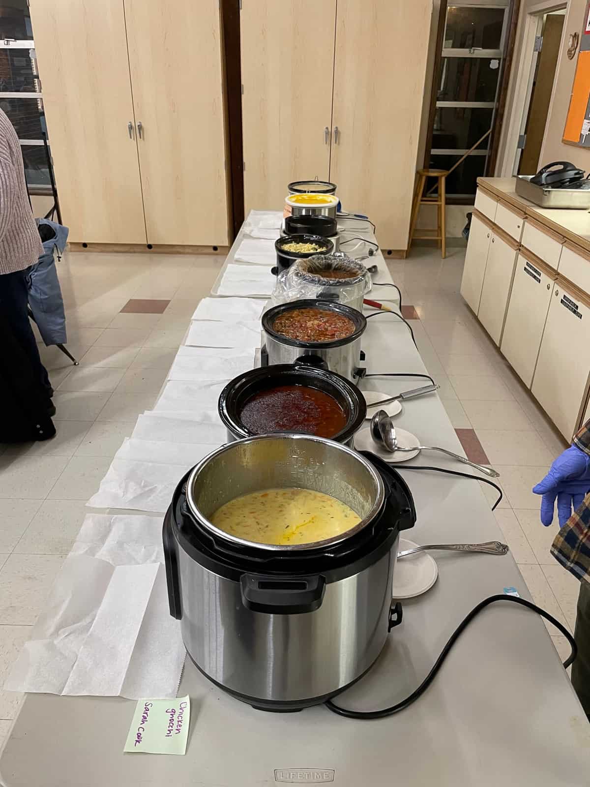 a table of crockpots and an instant pot full of soup.