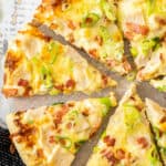 slices of chicken bacon ranch pizza on a grey wooden board.