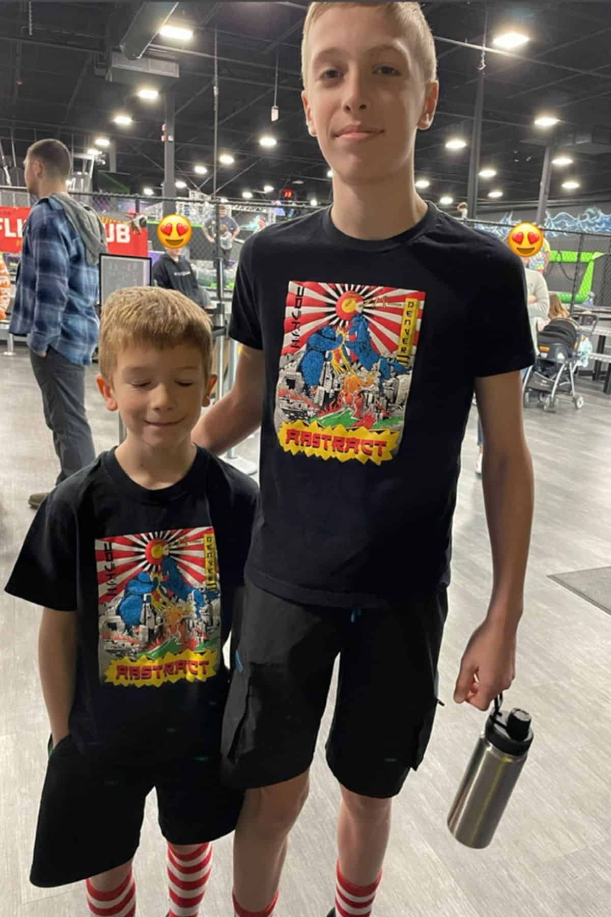 2 boys in matching clothes at an indoor jump place.