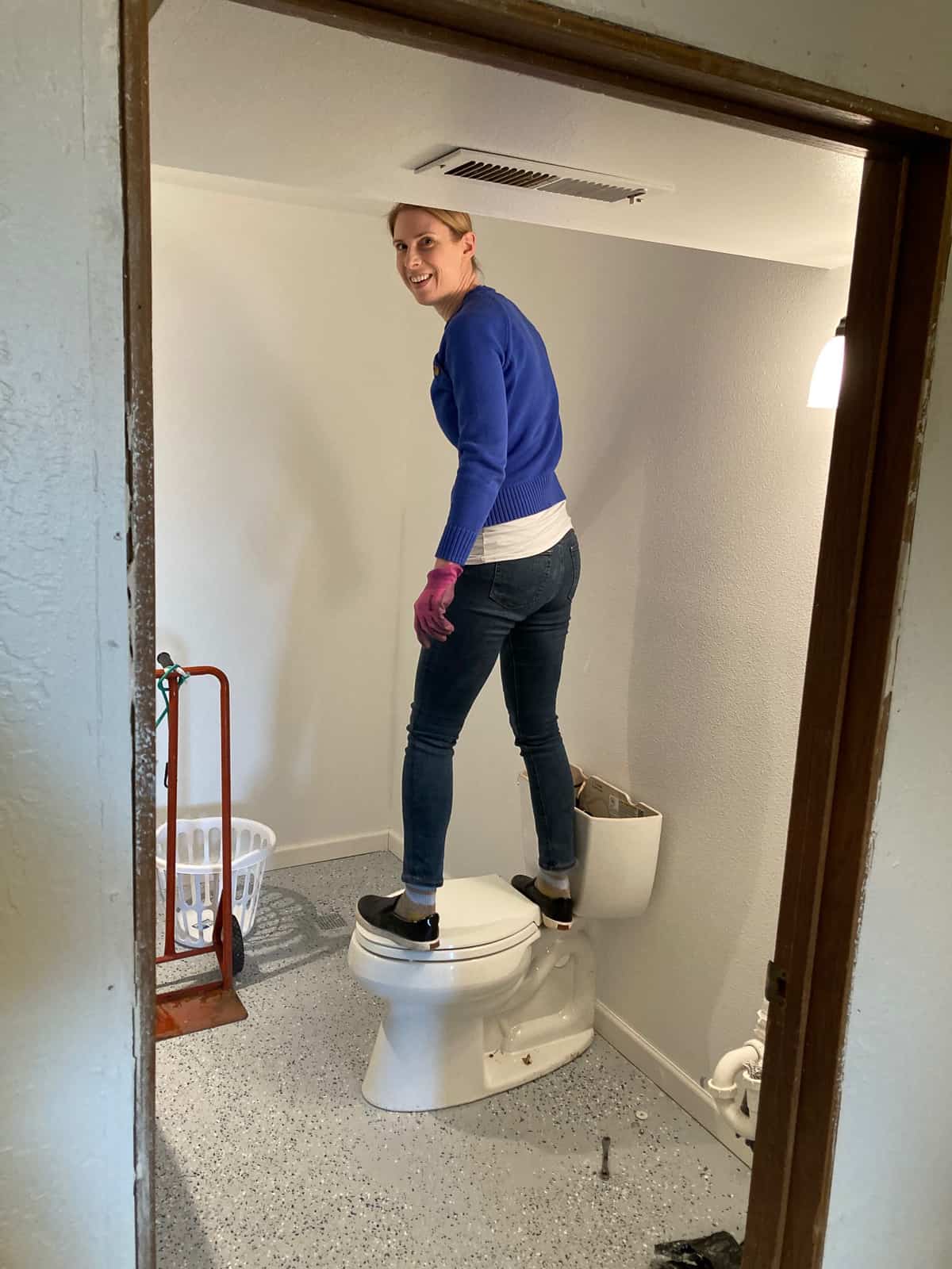 a woman standing on a toilet.