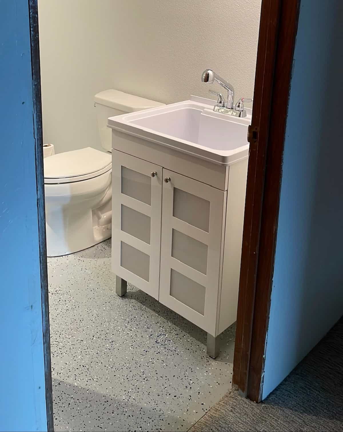 a white utility sink in a bathroom.