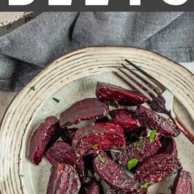 wedges of roasted beets on a plate topped with chopped parsley.