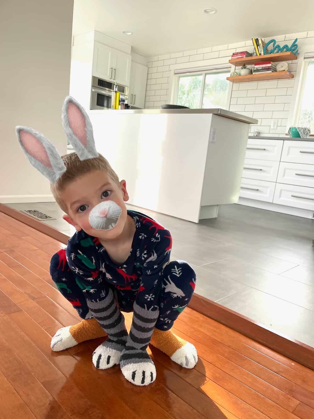 a kid dressed as a bunny in a kitchen.