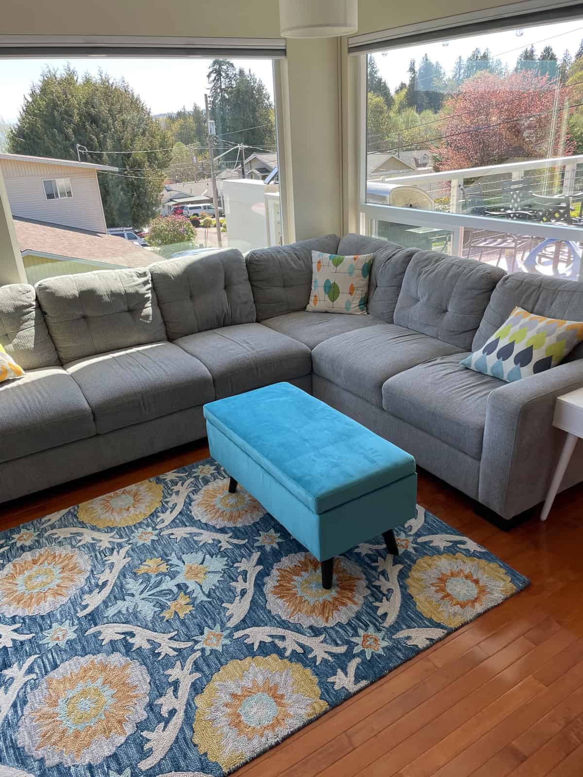 a living room with a teal footstool.