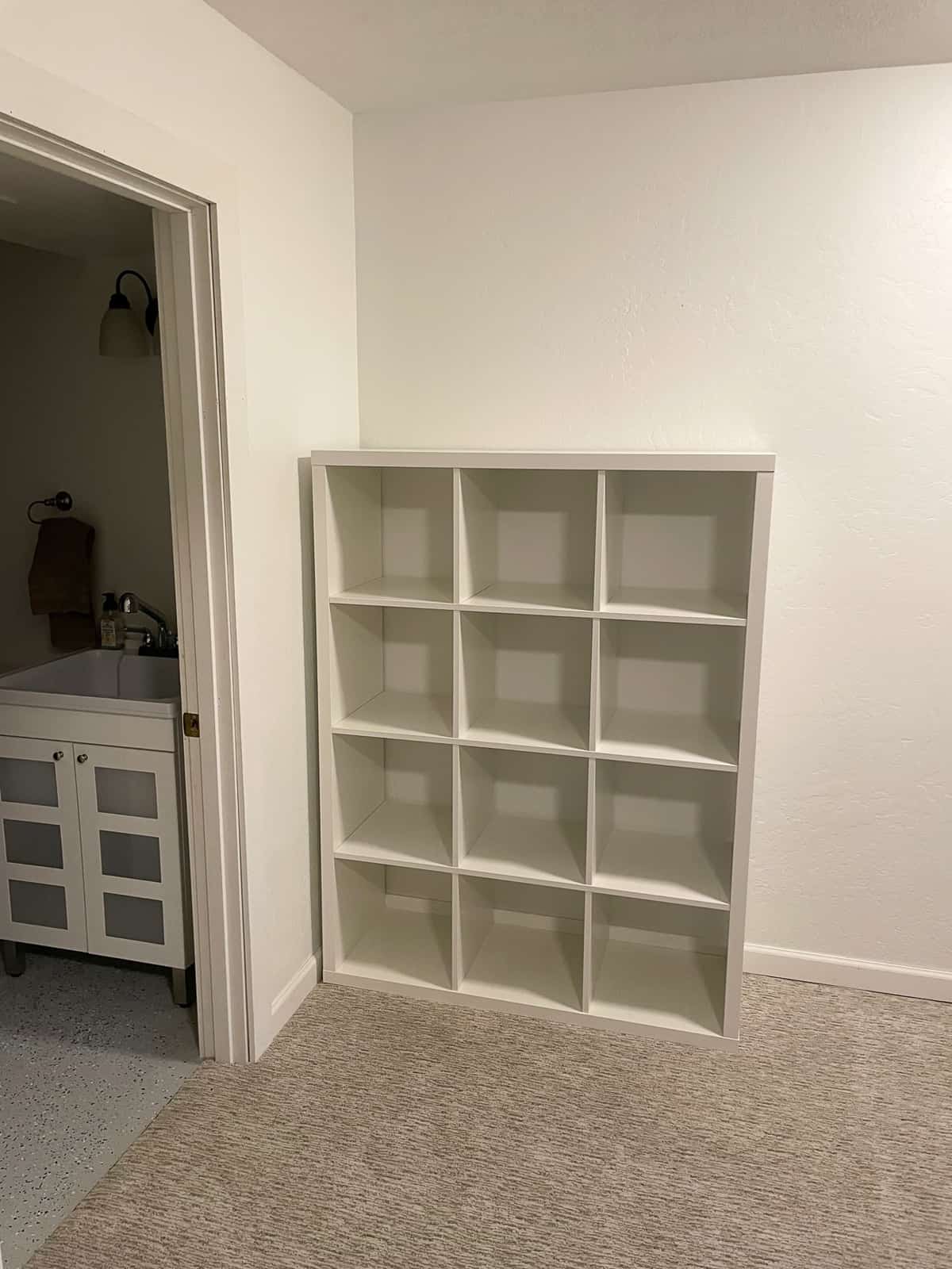 a KALLAX shelf from IKEA in a basement.