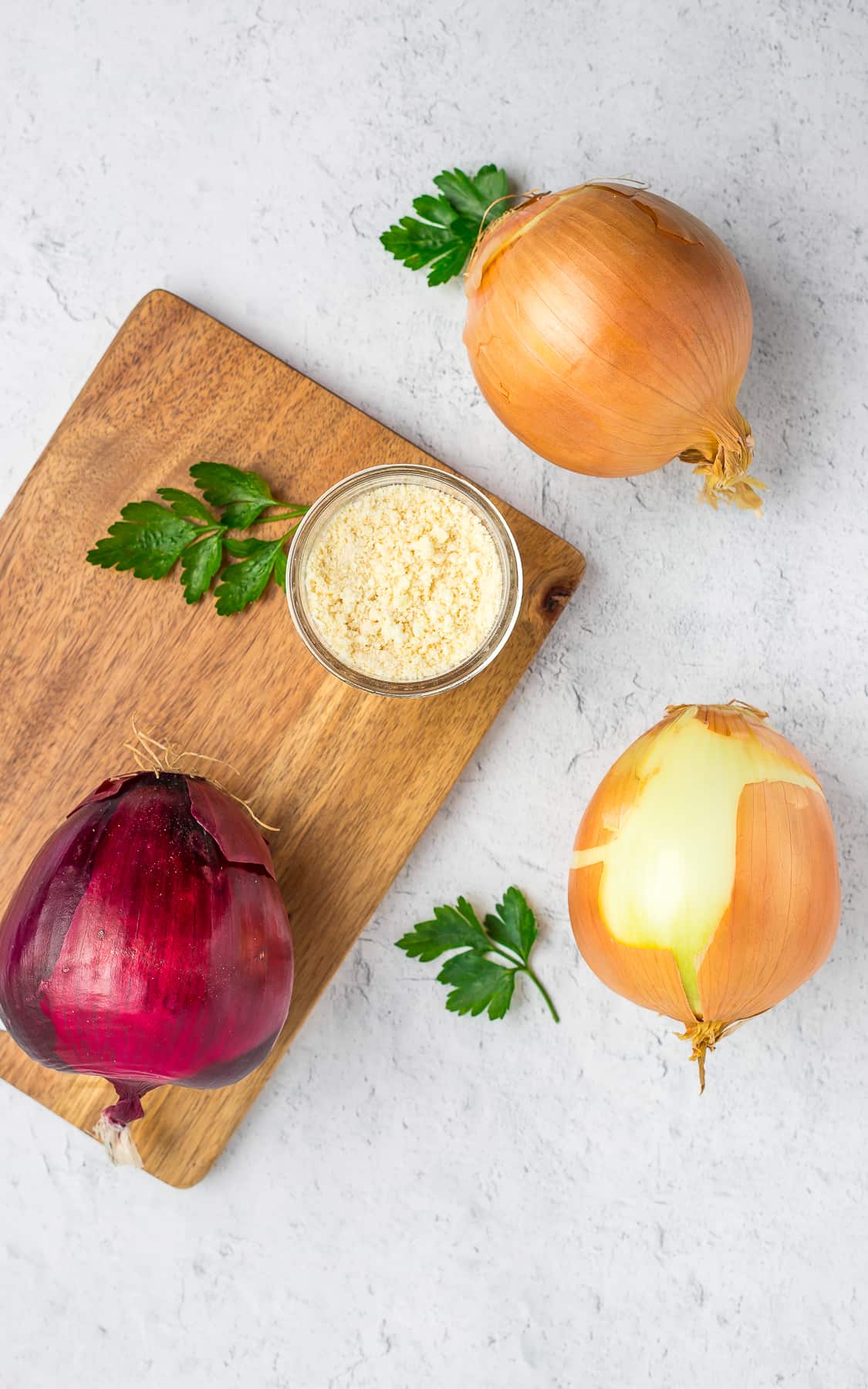 fresh onions on a board with a small dish of powdered onion.