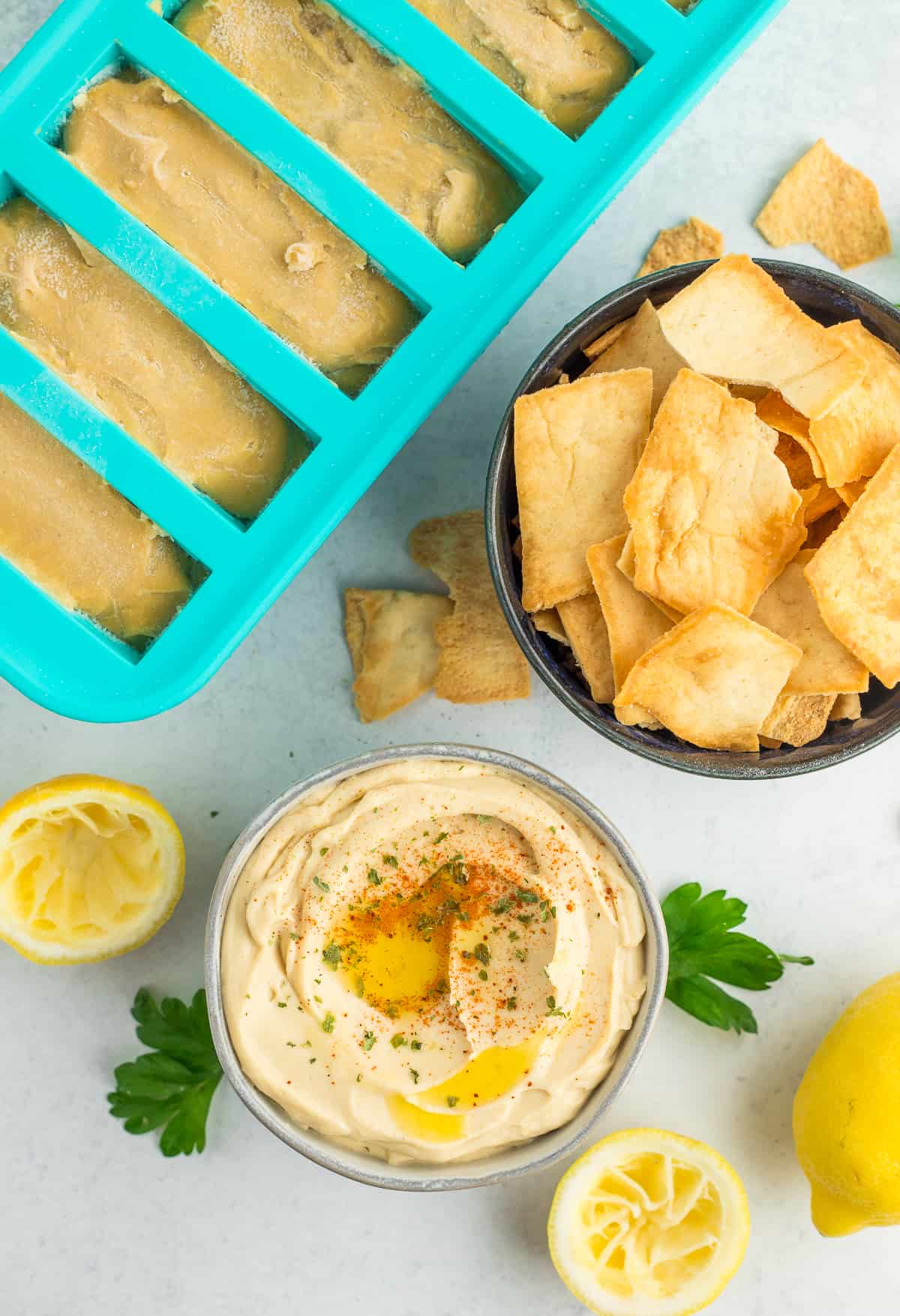 a bowl of hummus with a tray of frozen hummus.