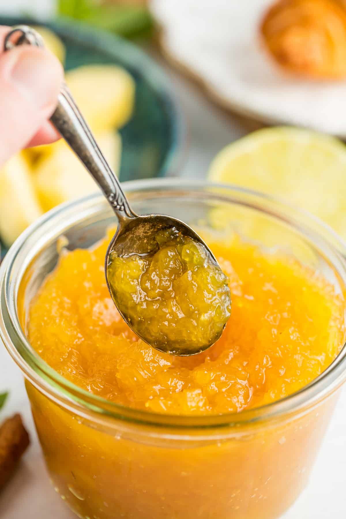 a spoonful of pineapple compote over a glass jar.