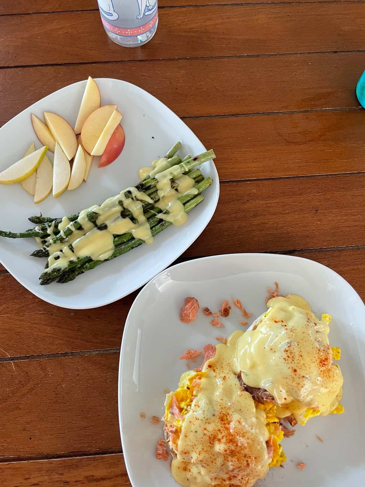 eggs benedict and asparagus on white plates.
