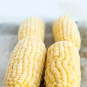 frozen ears of corn on a baking sheet.