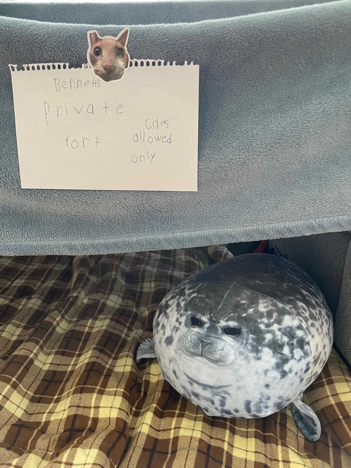 a stuffed seal in front of a sign for a fort.