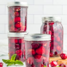 4 jars of canned cherries with mint.