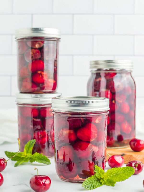 4 jars of canned cherries with mint.