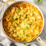 a white dish with buffalo chicken casserole topped with sliced green onions.