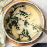 zuppa toscana in an Instant Pot with bowls and a ladle.