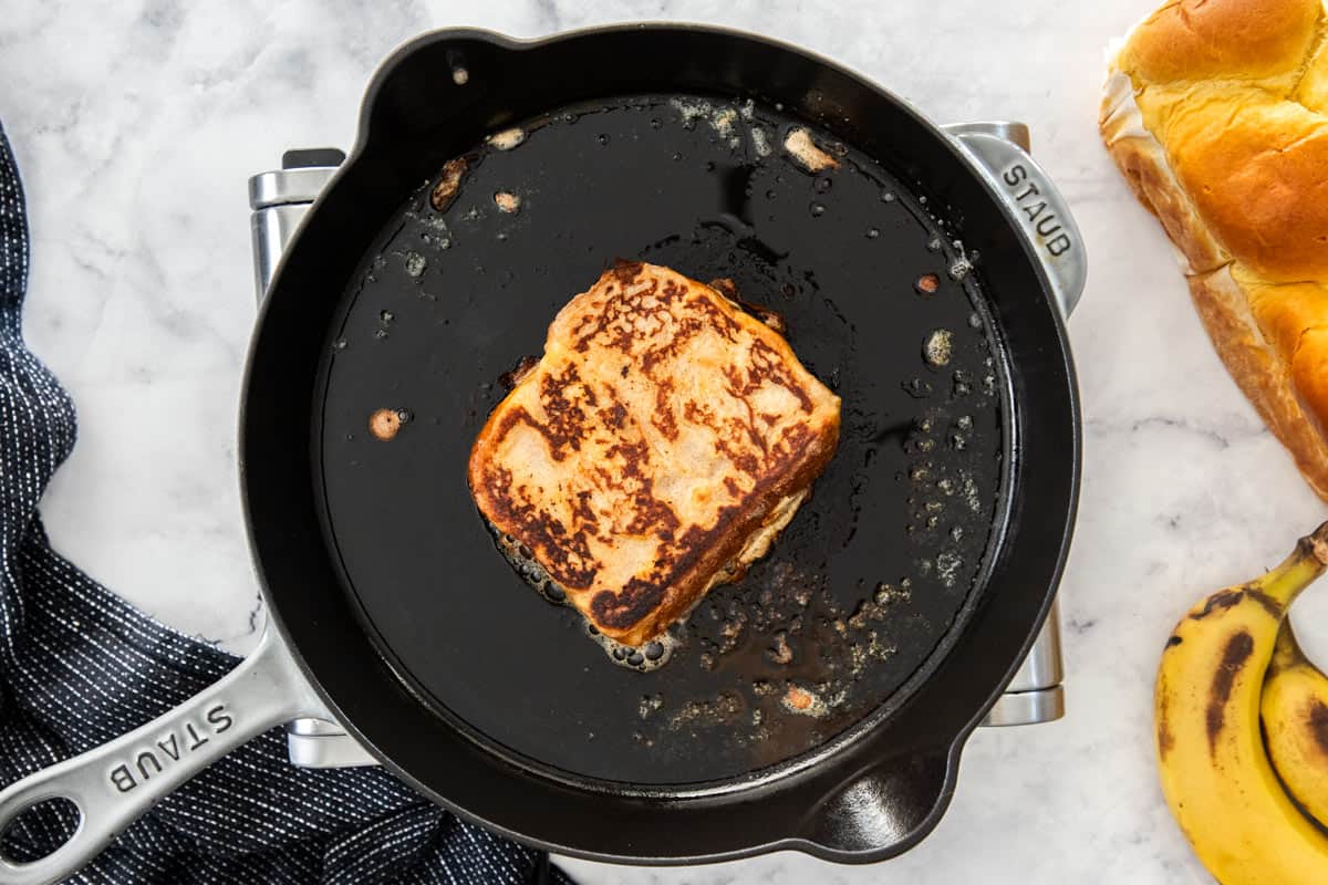 a slice of french toast in a cast iron skillet.