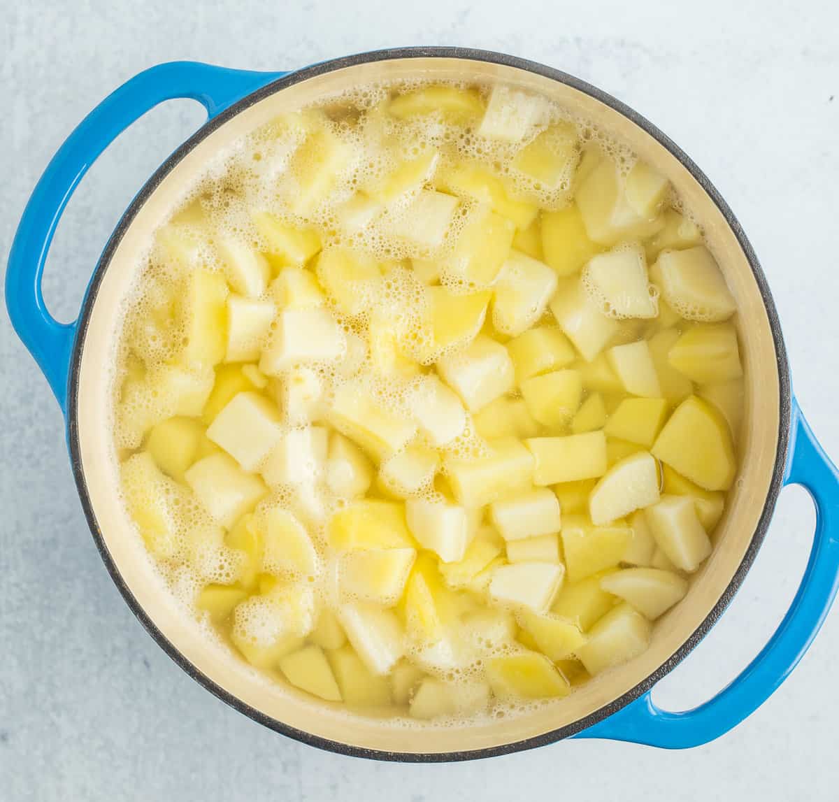 a blue casserole dish full of cubed potatoes.