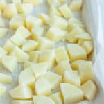 frozen cubed potatoes on a baking tray lined with parchment.