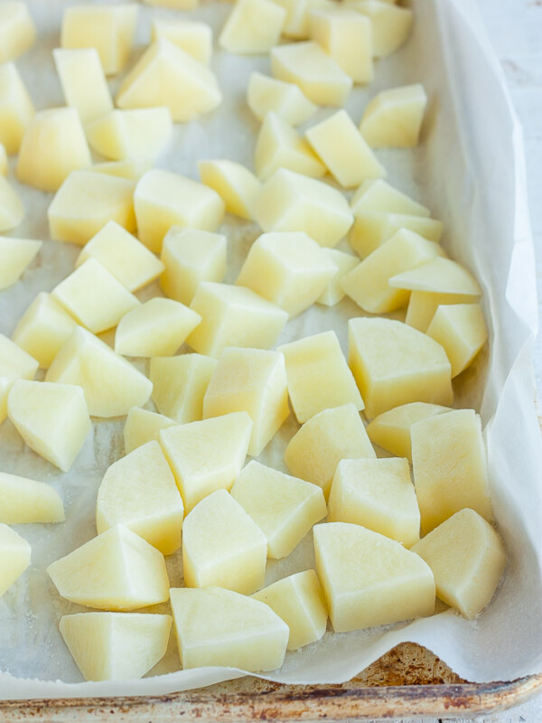 frozen cubed potatoes on a baking tray lined with parchment.