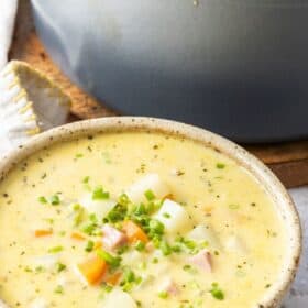 a grey bowl of ham and potato soup.