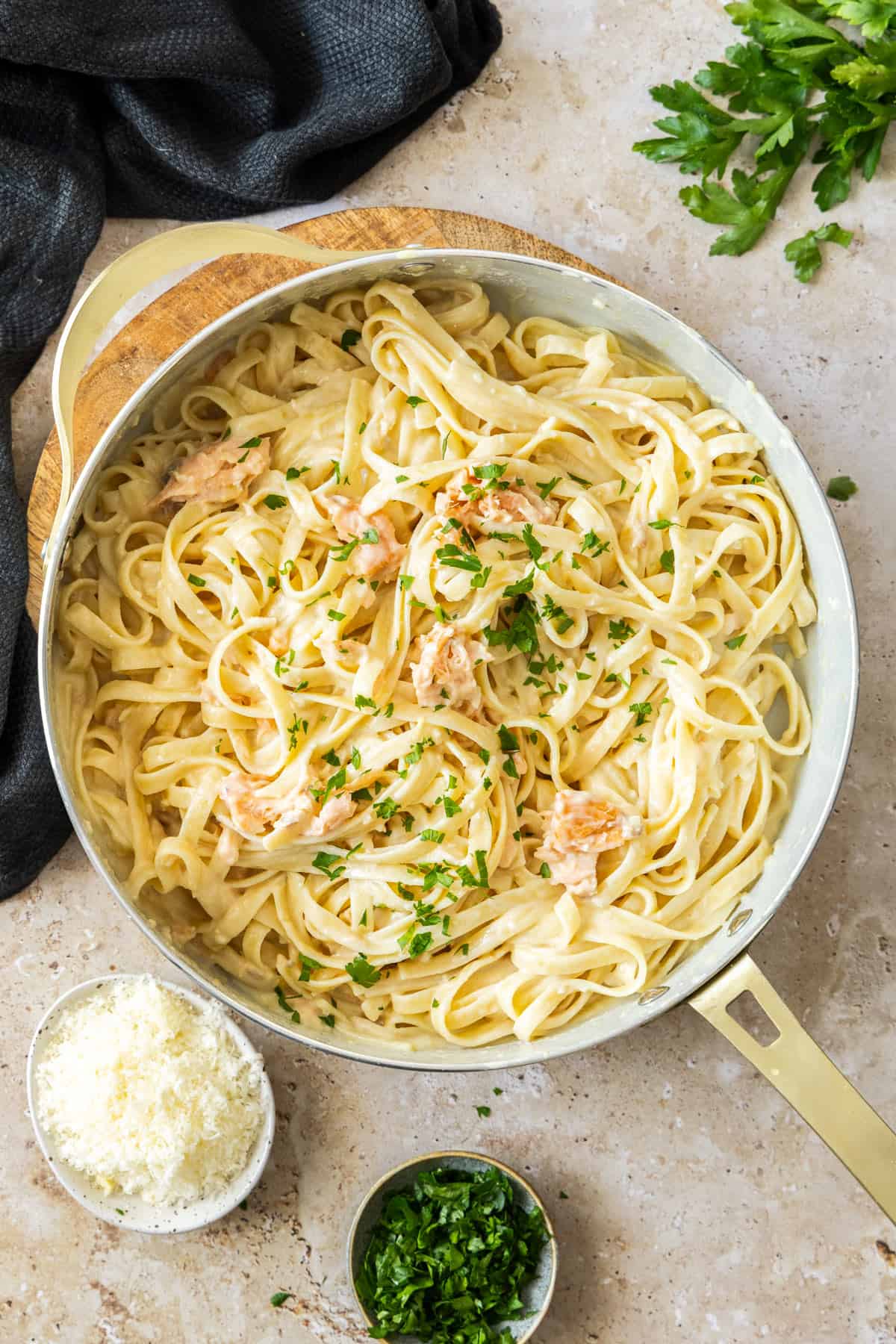  a white skillet with creamy smoked salmon pasta topped with chopped parsley.