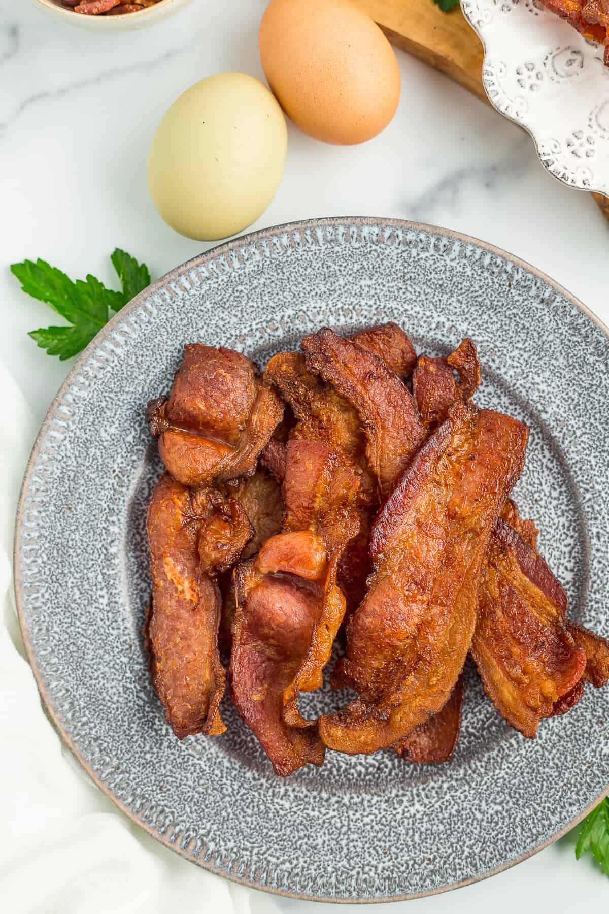 cooked bacon on a grey plate.