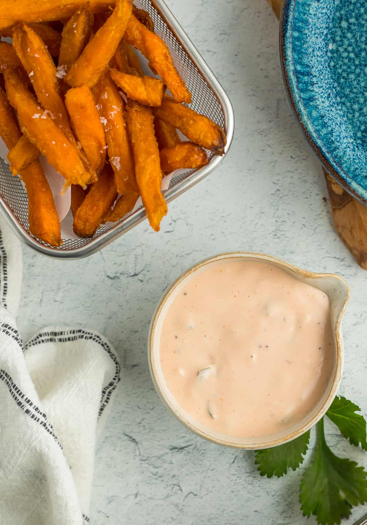 a bowl of fry sauce and a small basket of sweet potato fries.