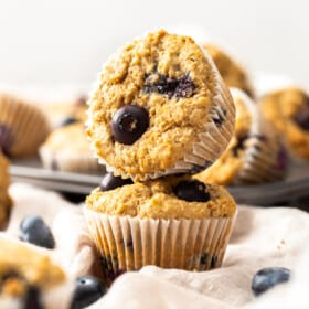Two whole wheat blueberry muffins stacked on top of each other.