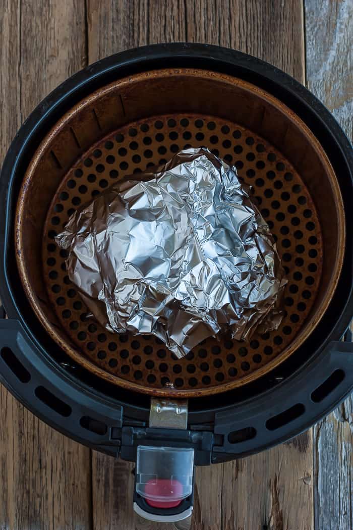 a bundle of foil in an air fryer basket.