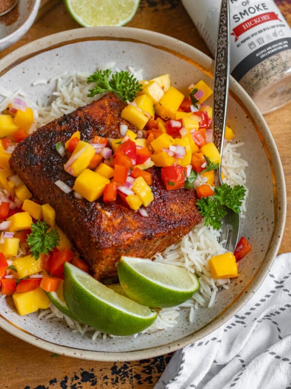 a plate with a piece of blackened mahi mahi topped with mango salsa.