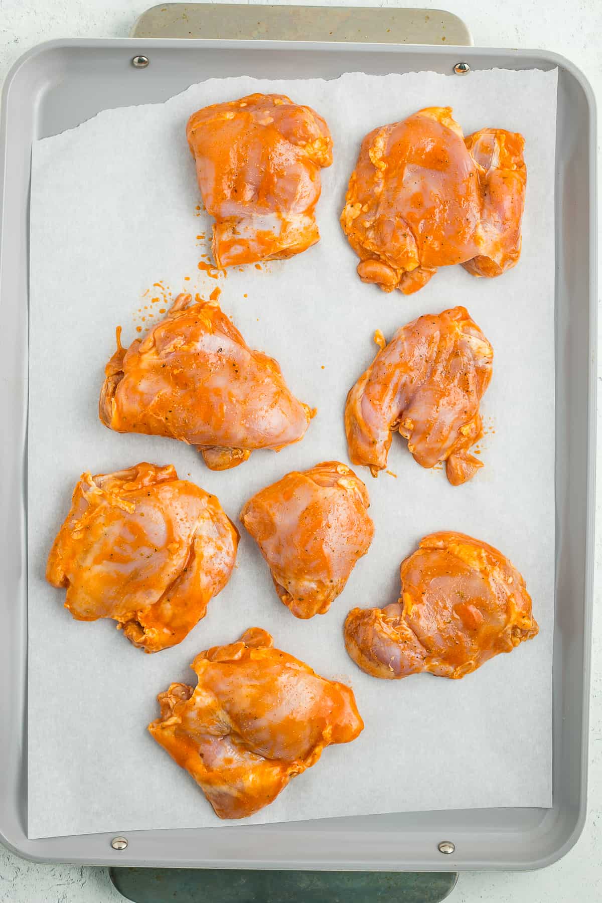raw chicken on a baking sheet.