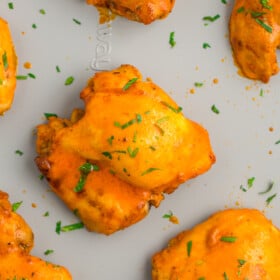 buffalo chicken thighs on a sheet pan.